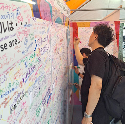 写真：ブースで自身の想いを乗せたメッセージの書き込む人